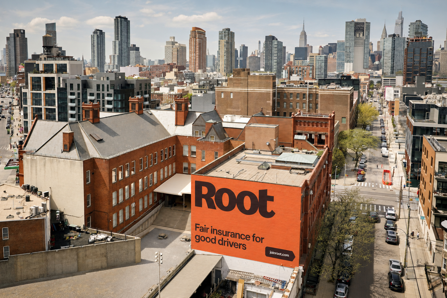 A city skyline above an orange Root wall advertisement reading Fair insurance for good drivers